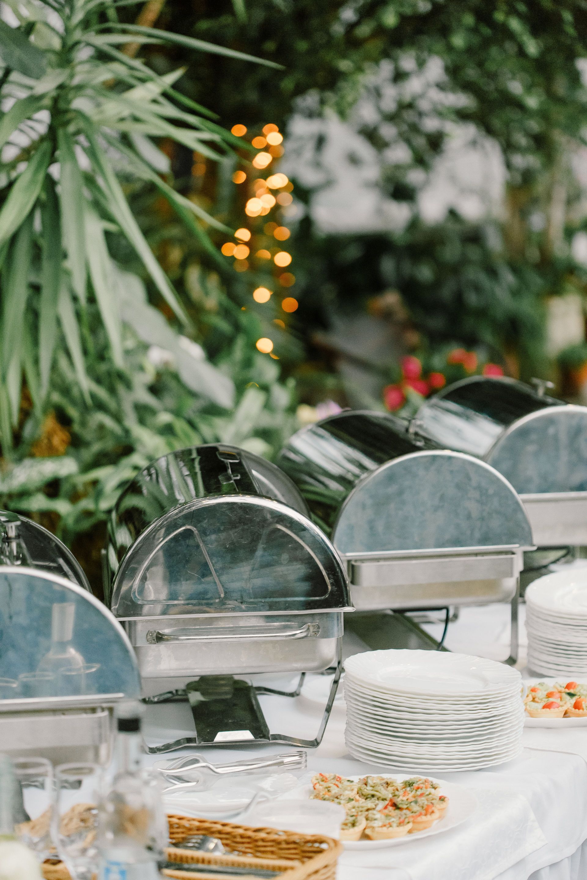 Buffet table with various food and appetizers placed on white tablecloth in outdoor restaurant
